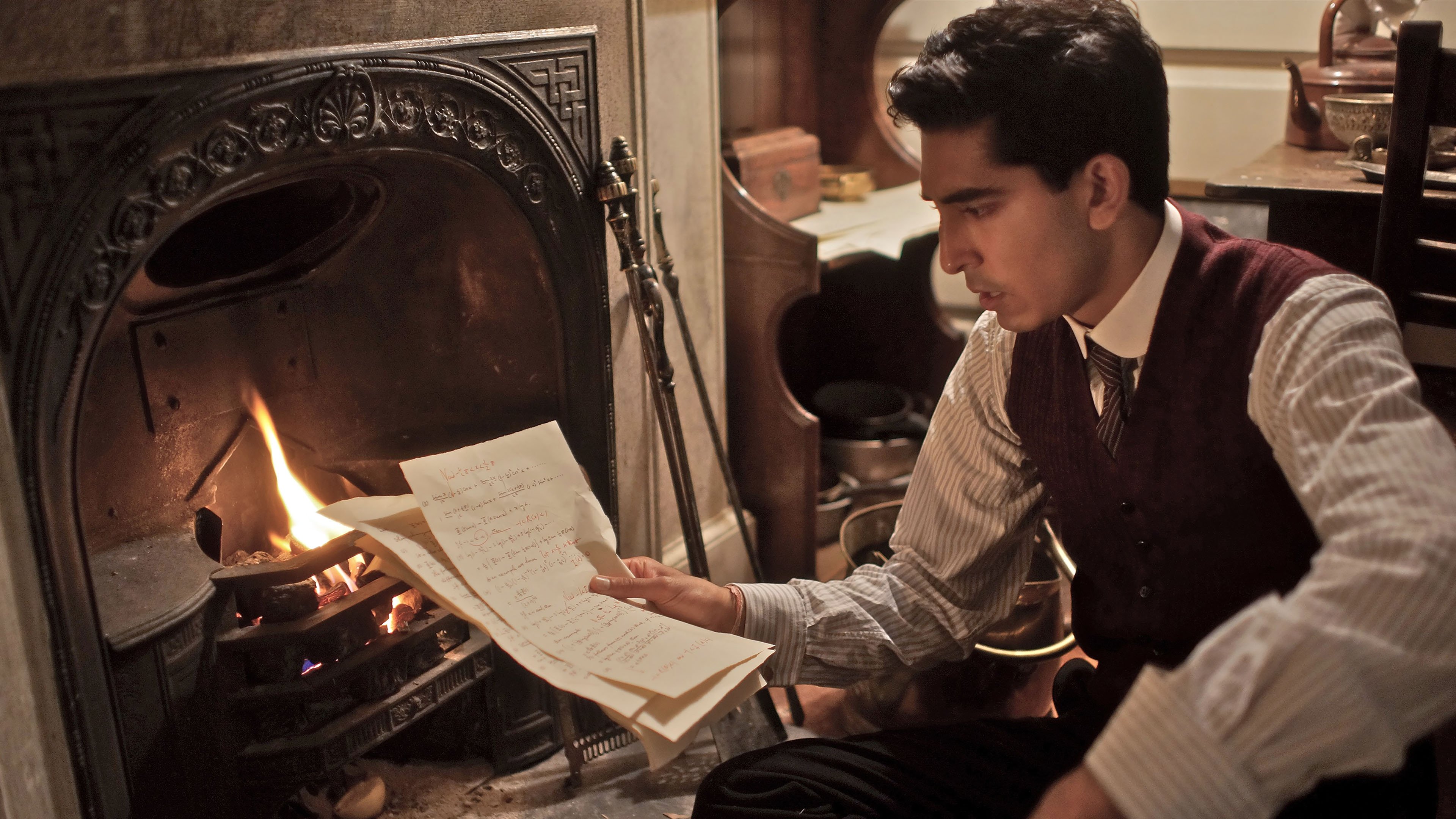 A director's clapperboard resting on a stack of old mathematics notebooks and a piece of chalk, warm tungsten light across a plain wooden desk, quiet and reflective mood, documentary style